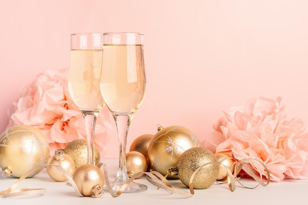 Champagne in glazen bekers gouden ballonnen sterren serpentine een pastel delicate roze achtergrond Nieuwjaar feestelijk concept