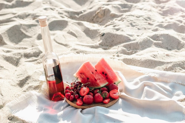 Champagne met een dienblad met fruit, aardbeien en kersen op een picknick