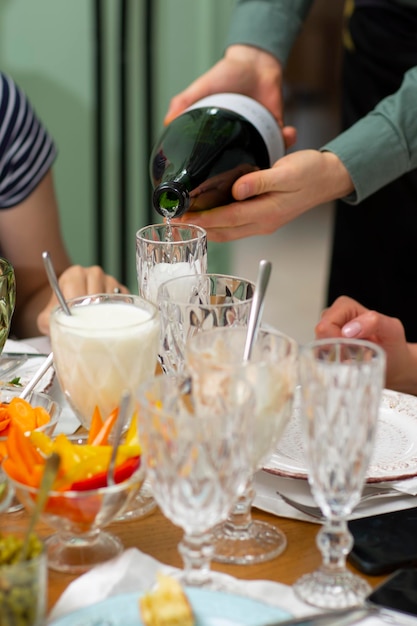 Champagne versare in bicchieri bicchieri sul tavolo
