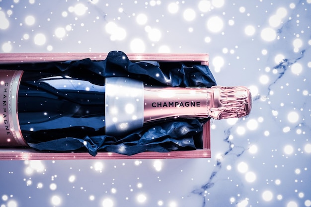 Champagnefles en geschenkdoos op blauwe vakantieglitter New Years Christmas Valentines Day wintercadeau en luxe productverpakking voor drankmerk