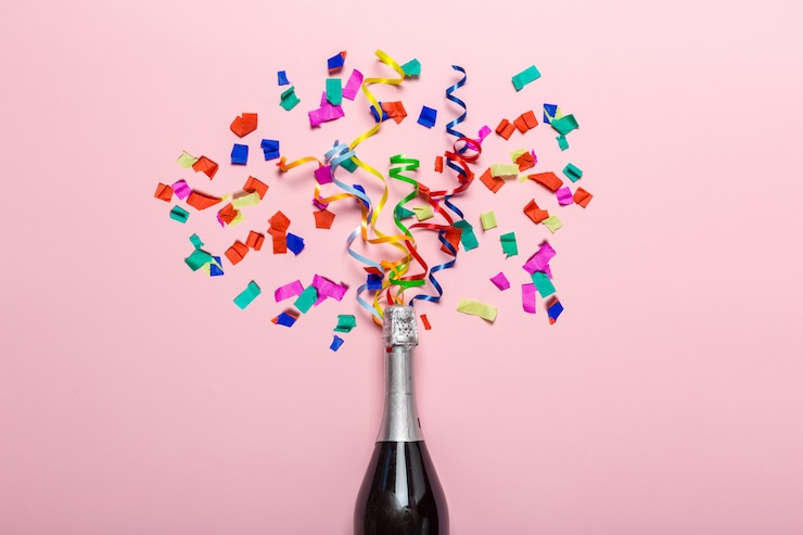 Foto champagnefles met kleurrijke feeststreamers