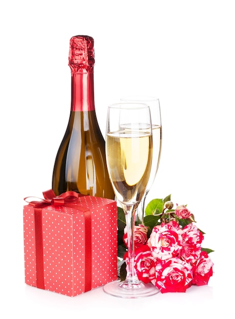 Champagnefles, twee glazen, geschenkdoos en roodroze bloemen. Geïsoleerd op witte achtergrond