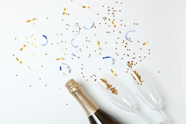 Champagneflesglazen en confetti op een gekleurd bovenaanzicht als achtergrond