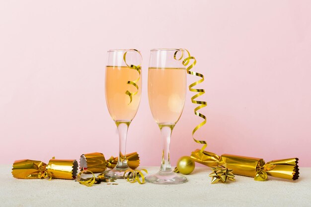 Foto champagneglasjes en kerstdecoratie op gekleurde vakantieachtergrond platte nieuwjaarsdecoraties