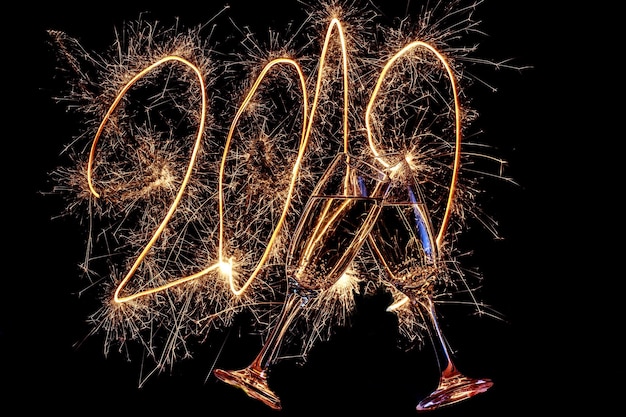 Foto champagneglasjes tegen vuurwerk tijdens een nieuwjaarsfeest