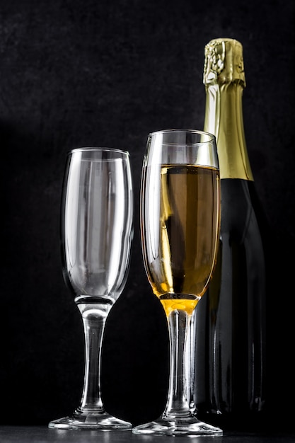 Champagneglazen en fles op zwarte achtergrond