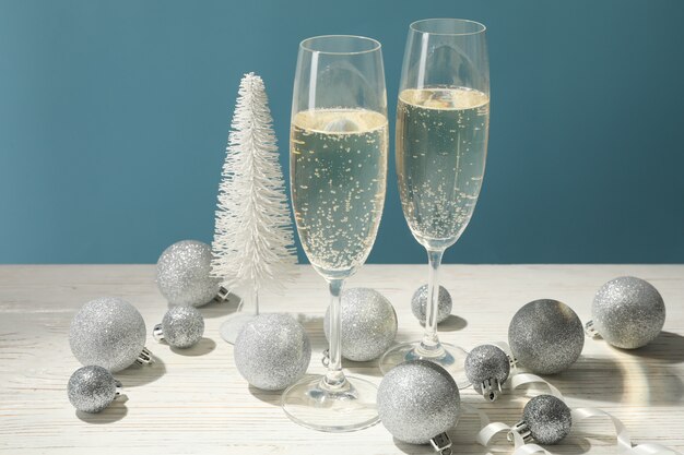 Champagneglazen en kerstballen tegen blauwe ruimte, ruimte voor tekst