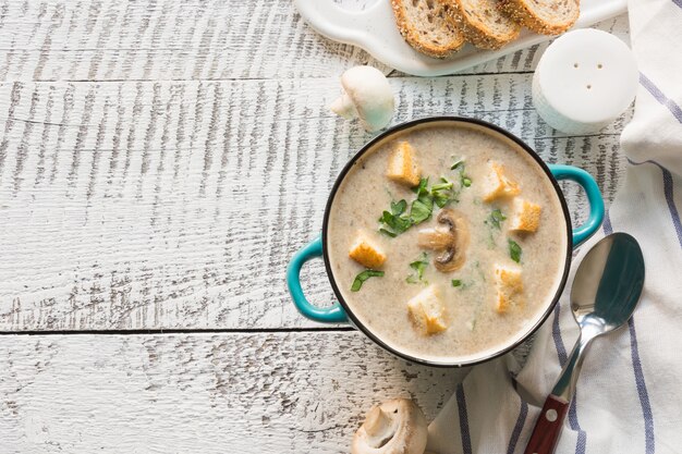 Champignon Champignon roomsoep op witte houten bord. Uitzicht van boven. Ruimte voor tekst.