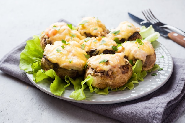 Champignon mushrooms stuffed with cheese, chicken and herbs baked in oven