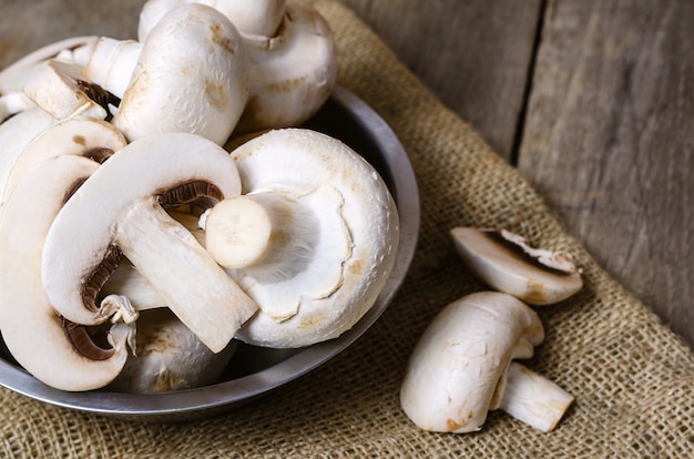 Champignon mushrooms on a wooden cbackground