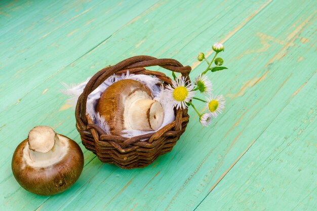 Champignons champignons en rieten mand met een veld bloem.