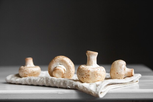 Champignons champignons op het keukenservet op een witte houten tafel Plaats voor tekst of reclame