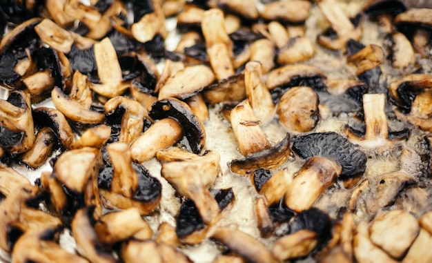 Champignons fry on a large baking sheet Extreme close up