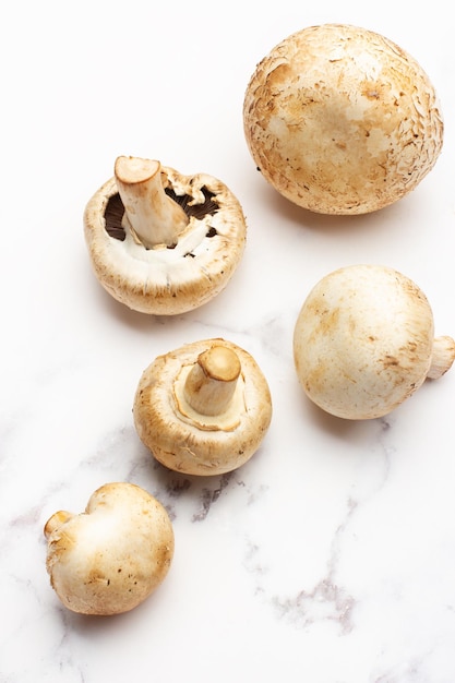 Champignons on a gray and white marble kitchen countertop in a top view