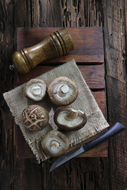 Champignons op een tafel met een mes en een houten blok.