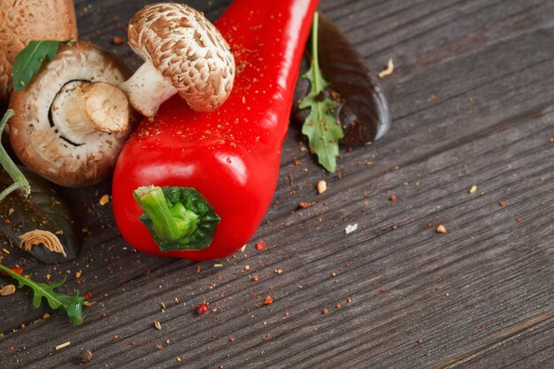 Champignons, tomaten, peper en knoflook op een houten tafel