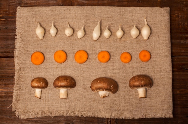 Champignons ui en plakjes wortel liggen op een servet op tafel
