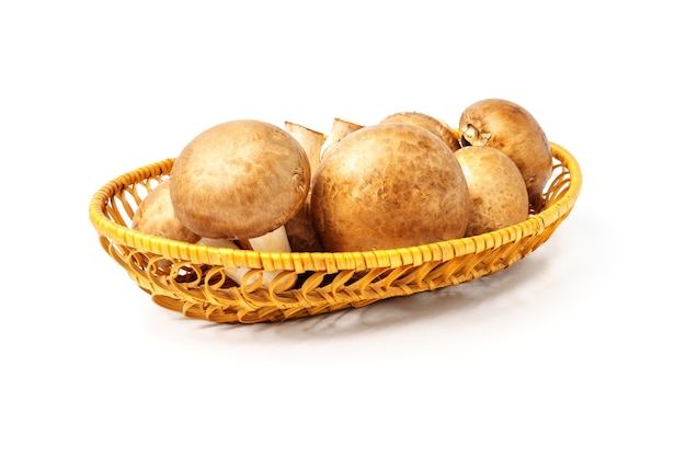 Champignons in a wicker plate isolated on white wall