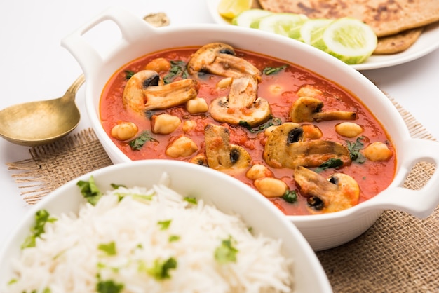 Champignonsabzi in tomatencurry met kikkererwten en spinazie, Indiaas hoofdgerecht menu geserveerd met Paratha en gekookte witte rijst