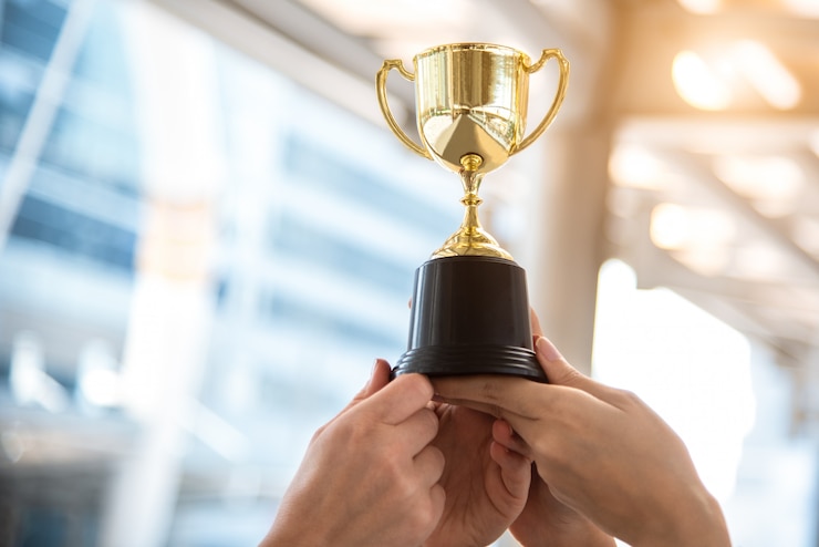 Photo champion golden trophy for winner with sport player hands in sport stadium 