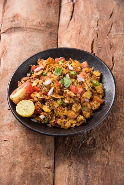 Chana chor jor garam - Indian roadside spicy chat or snack food, served in a plate or bowl over colourful or wooden background. Selective focus