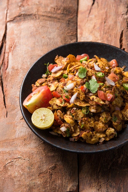 chana chor jor garam - indian roadside spicy chat or snack food, served in a plate or bowl over colourful or wooden background. selective focus