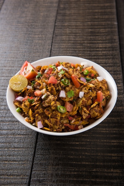 Chana chor jor garam - 인도 길가의 매운 잡담이나 스낵 음식은 다채롭거나 나무 배경 위에 접시나 그릇에 제공됩니다. 선택적 초점