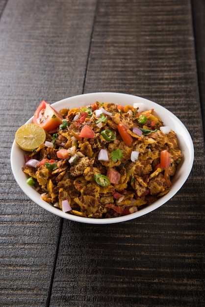 Chana chor jor garam - Indian roadside spicy chat or snack food, served in a plate or bowl over colourful or wooden background. Selective focus