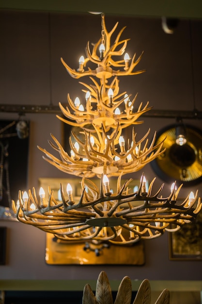 A chandelier with antlers and candles is displayed in a store.