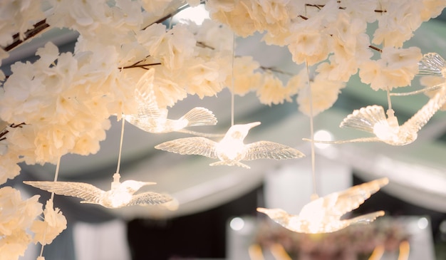 A chandelier with white birds hanging from it