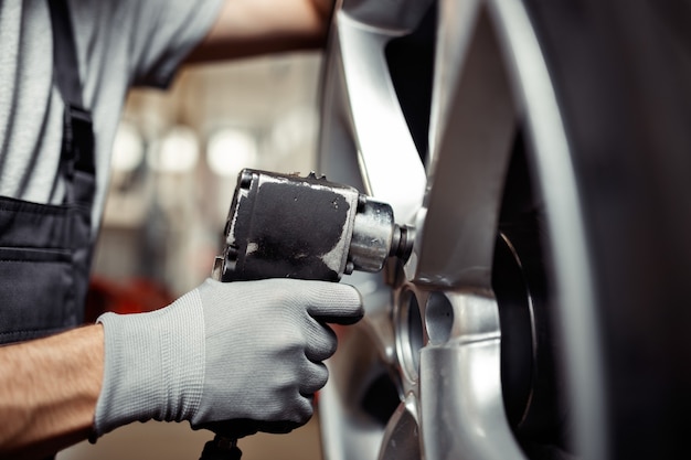 Changing a tire at a car service: vehicle repair workshop.