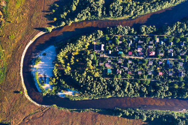 The channel and bends of the river on a marshy meadow Orange dry grass scorched by the summer heat and morning fog A wonderful landscape at dawn Drone view