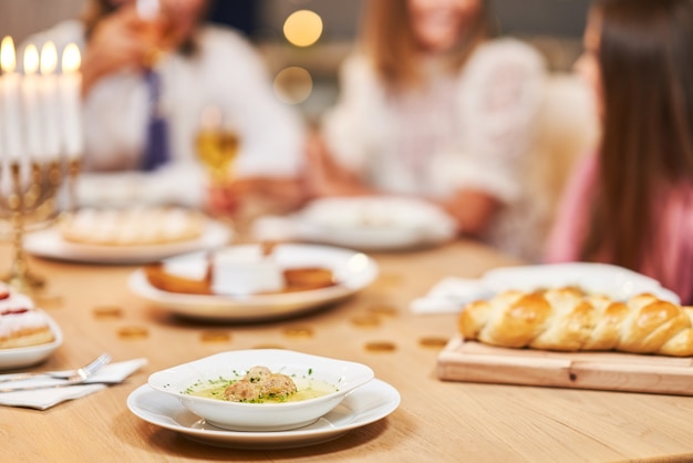 Chanoeka diner. Familie verzameld rond de tafel met traditionele gerechten