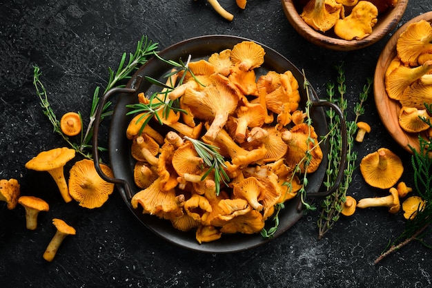 Chanterelle mushrooms in a bowl Organic forest food Top view On a stone background