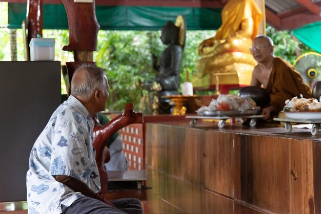 チャンタブリー、タイ-2017年5月29日：タイの寺院（ワットタイ）で食べ物やその他の仏教信仰の宗教儀式を祈る正体不明のタイの僧侶