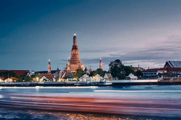 バンコクのスカイラインに沿ったチャオフラヤ川と夕暮れの寺院ワト・アルーン (Temple Wat Arun) はタイの首都である