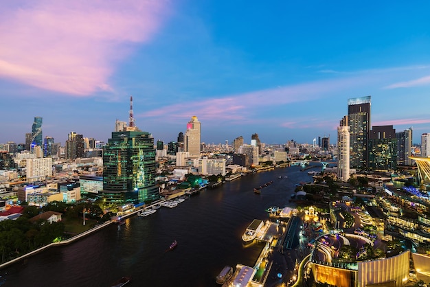 Chao Phraya-rivier met Taksin-brug en de bouw van de stad van Bangkok bij schemering Thailand