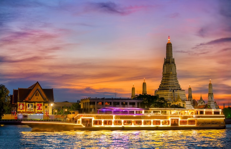 Foto chao phraya-riviercruiseboot met tempel van de dageraad, wat arun, bij zonsondergang op horizontale achtergrond ,.