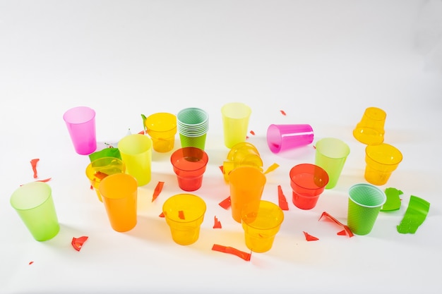 Chaotic consumption . Bunch of colorful plastic cups being broken and thrown in unprocessed state