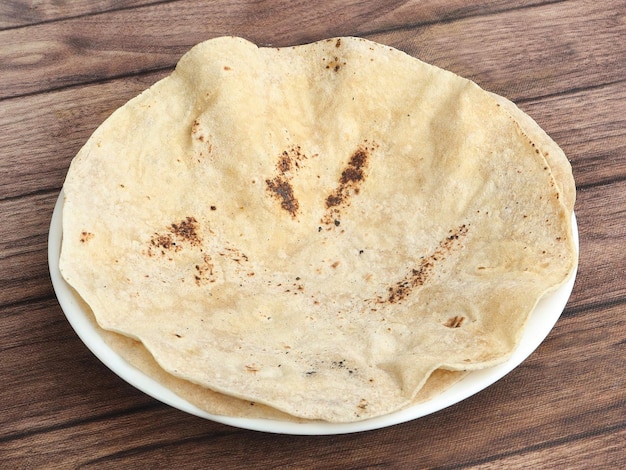 Foto chapati isolato su uno sfondo di legno rustico fuoco selettivo