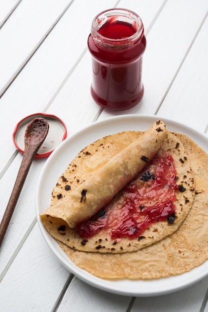 Chapati Roll met tomatenketchup of fruitjam Jelly met lachend gezicht, het favoriete voedselmenu van indiase kinderen voor schooltiffin-doos, selectieve focus