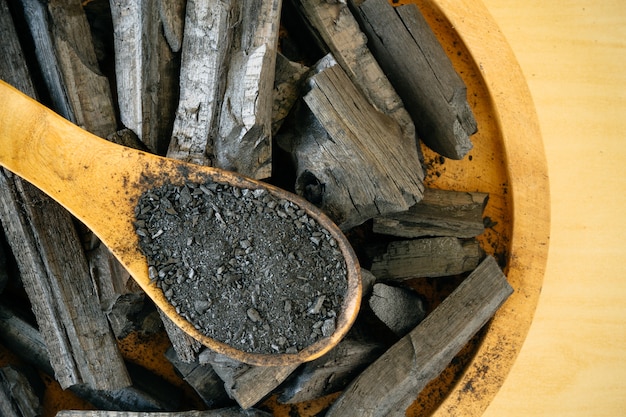 Charcoal and charcoal powder on wooden spoon. 