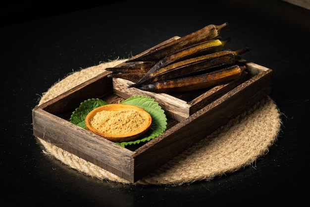 Charcoal roasted okra on a dark background