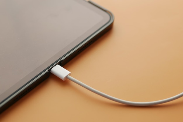 Photo charging smart phone with a cable on color background