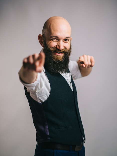 Photo charismatic bearded man smiles into the camera and gestures with his hands