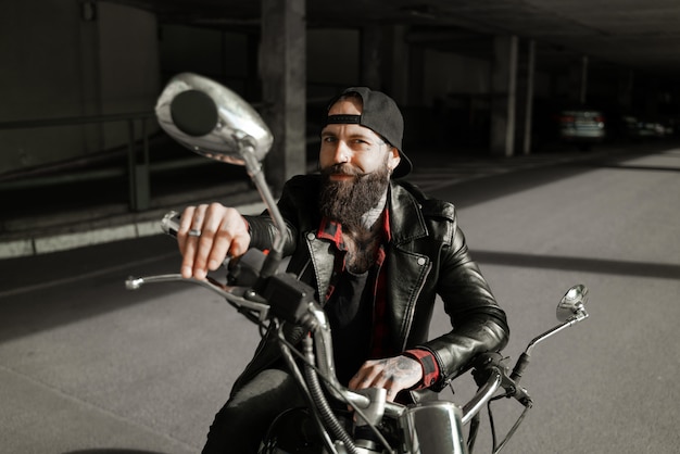 Foto motociclista carismatico su una moto sorridente