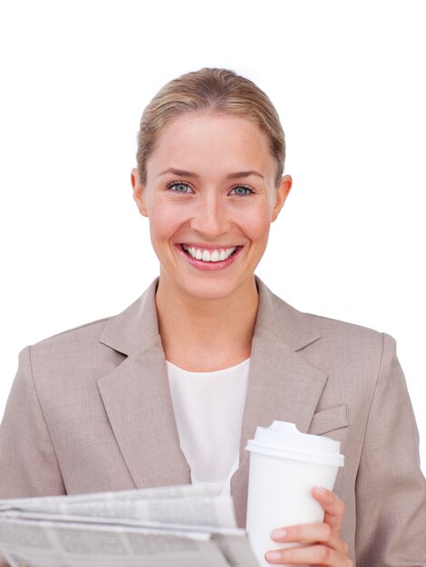 Charismatic businesswoman drinking a coffee reading a newspaper