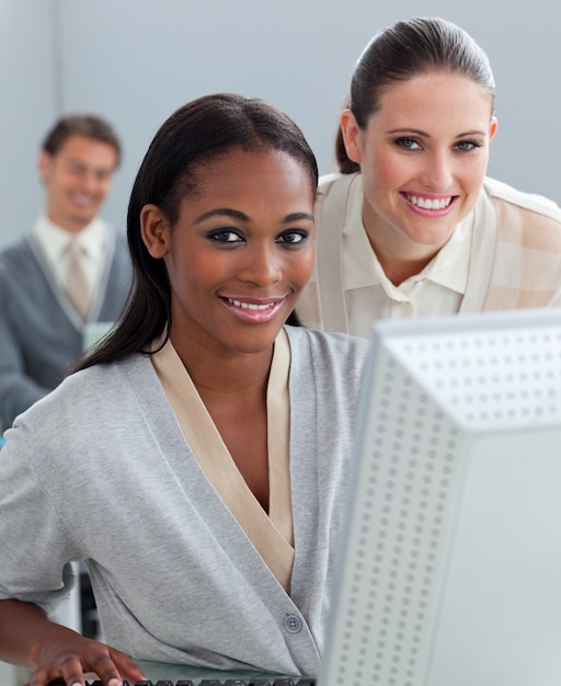 Charismatic businesswoman helping her colleague at a computer