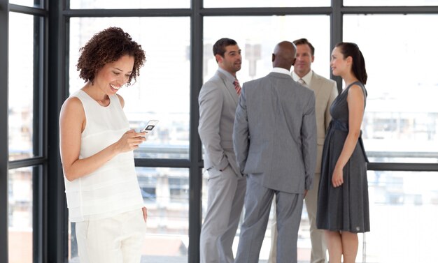 Charismatic businesswoman on phone in office with her team