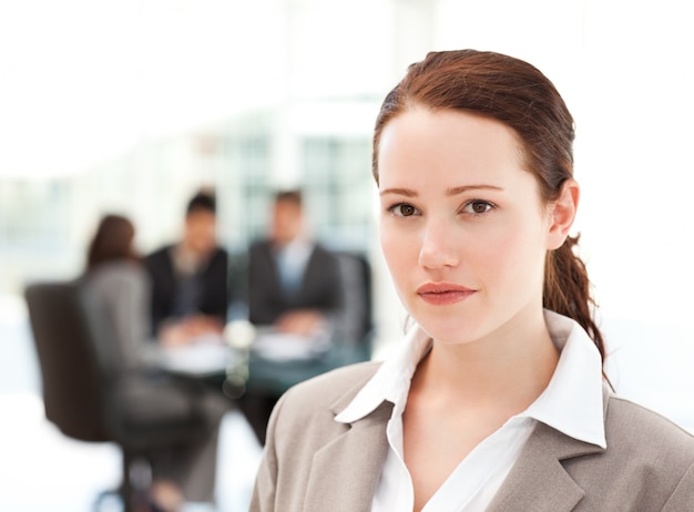 Charismatic businesswoman standing in the foreground while her team his working